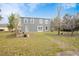 Spacious backyard with a well-maintained lawn, landscaping, and an exterior view of the home's back at 3894 Arborvitae Way, Deland, FL 32724