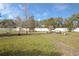 Expansive fenced backyard featuring a stone pathway, lush lawn, mature trees and decorative benches at 3894 Arborvitae Way, Deland, FL 32724