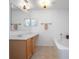Bright bathroom with dual sinks, wood cabinetry, and separate tub at 3894 Arborvitae Way, Deland, FL 32724