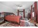 Bedroom featuring carpet, ceiling fan, and a comfy bed with red bedding at 3894 Arborvitae Way, Deland, FL 32724