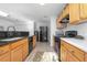 A cozy kitchen with a tile floor, wood cabinets, and a suite of black appliances at 3894 Arborvitae Way, Deland, FL 32724