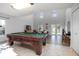 Bright living room with vaulted ceilings, pool table and a seamless transition to the outdoor scenery at 3894 Arborvitae Way, Deland, FL 32724