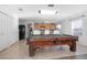 An open concept living room with pool table adjacent to the kitchen and casual dining area at 3894 Arborvitae Way, Deland, FL 32724