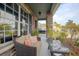 Covered porch with comfortable seating area and stone pillar accents at 3894 Arborvitae Way, Deland, FL 32724