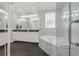 Modern bathroom with dual sinks, a soaking tub, and sleek, dark flooring at 411 Foxhill Dr, Debary, FL 32713