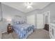 Cozy bedroom with neutral walls, ceiling fan, and a comfortable bed dressed in a patterned comforter at 411 Foxhill Dr, Debary, FL 32713
