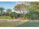 Home exterior with mature landscaping including palms and lush, green vegetation at 411 Foxhill Dr, Debary, FL 32713