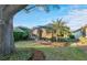 Beautiful screened-in lanai surrounded by lush landscaping and a mature palm tree in backyard at 411 Foxhill Dr, Debary, FL 32713