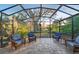 Screened-in porch with comfortable seating overlooking a lush outdoor landscape and manicured lawn at 411 Foxhill Dr, Debary, FL 32713