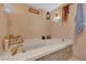 Inviting bathtub with a gold faucet and textured tile border at 4612 Reynosa Sw Dr, Winter Haven, FL 33880