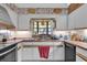 Bright kitchen featuring white cabinets, tile countertops, and a large window for natural light at 4612 Reynosa Sw Dr, Winter Haven, FL 33880