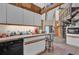 Cozy kitchen with white cabinets, tile countertops, and an open view to a second floor spiral staircase at 4612 Reynosa Sw Dr, Winter Haven, FL 33880