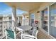 Cozy balcony setup with striped chairs, a table, and a barbecue grill, perfect for outdoor dining at 4670 Links Village Dr # B706, Ponce Inlet, FL 32127