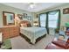 Comfortable bedroom with a full-sized bed, dresser, ceiling fan, and soft natural light at 4670 Links Village Dr # B706, Ponce Inlet, FL 32127