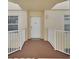 View of the front door in a condo with a white railing and landing at 4670 Links Village Dr # B706, Ponce Inlet, FL 32127