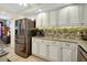 Kitchen with stainless steel refrigerator and ample white cabinets at 4670 Links Village Dr # B706, Ponce Inlet, FL 32127