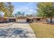 Charming single-story home featuring a two-car garage, stone accents, and a well-maintained front yard at 49 Crooked Pine Rd, Port Orange, FL 32128