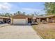 Charming single-story home featuring a two-car garage, stone accents, and a well-maintained front yard at 49 Crooked Pine Rd, Port Orange, FL 32128