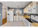 Spacious kitchen with white tile floor, appliances, and butcher block countertops at 49 Crooked Pine Rd, Port Orange, FL 32128