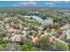 A bird's eye view showing the proximity of a pond near a house with a tiled roof, set amid lush trees at 509 Osprey Ln, Winter Springs, FL 32708