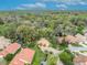 Wide aerial shot of homes with terracotta roofs, complemented by verdant trees, landscaping, and paved driveways at 509 Osprey Ln, Winter Springs, FL 32708