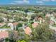 An impressive aerial view showcases a lovely home with a terra cotta roof nestled within a lush, green neighborhood by a lake at 509 Osprey Ln, Winter Springs, FL 32708