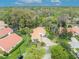 Aerial view of home featuring tile roof, front yard, mature trees, and a brick driveway at 509 Osprey Ln, Winter Springs, FL 32708