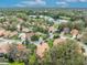 Overhead shot showcasing houses with red tile roofs nestled in a tree-filled neighborhood by a serene pond at 509 Osprey Ln, Winter Springs, FL 32708