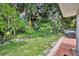 Relax on this backyard's patio, a perfect spot for entertaining with a lush lawn and mature trees at 509 Osprey Ln, Winter Springs, FL 32708