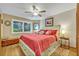 Cozy bedroom with wood floors, a ceiling fan, and a window overlooking greenery, creating a peaceful atmosphere at 509 Osprey Ln, Winter Springs, FL 32708