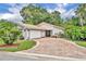 Charming single-story home with a tile roof, brick driveway, and lush landscaping at 509 Osprey Ln, Winter Springs, FL 32708