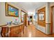 Inviting hallway featuring hardwood floors, ornate chest, and doorway to adjacent room with a fireplace at 509 Osprey Ln, Winter Springs, FL 32708