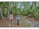 Community nature trail with marked signage amidst lush greenery, inviting residents to explore at 509 Osprey Ln, Winter Springs, FL 32708