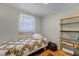 Cozy bedroom features a colorful quilt, window with lace curtains, and wooden shelves at 53722 Rivertrace Rd, Astor, FL 32102