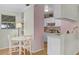 Dining nook with a table, adjacent to a kitchen area with white cabinetry and views of the backyard at 53722 Rivertrace Rd, Astor, FL 32102