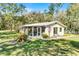 Inviting single-story home with a screened porch, lush lawn and mature trees in a serene setting at 53722 Rivertrace Rd, Astor, FL 32102