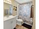 Bathroom with a modern vanity, stylish mirror, and a shower curtain, blending comfort and convenience at 605 Anderson Dr, Deltona, FL 32725
