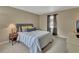 Comfortable bedroom with a striped bedspread, side table, lamp, and a window view at 605 Anderson Dr, Deltona, FL 32725