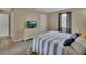Inviting bedroom features a striped bedspread, dresser with tv, and neutral décor at 605 Anderson Dr, Deltona, FL 32725