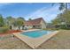 Inviting pool with lounge chairs, set against a lush yard and the home's exterior, perfect for leisure at 605 Anderson Dr, Deltona, FL 32725