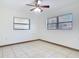 A bright bedroom featuring neutral tile flooring, a ceiling fan, and two windows at 61 West Highbanks, Debary, FL 32713