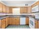 Well-lit kitchen featuring wood cabinets, dark countertops, and white appliances at 61 West Highbanks, Debary, FL 32713
