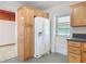 Kitchen area with wood cabinets, white refrigerator, and access to the back door at 61 West Highbanks, Debary, FL 32713