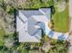 Aerial view of a well-maintained house with a gray roof, complemented by a curved driveway and lush landscaping at 65 Calumet Ave, Ponce Inlet, FL 32127
