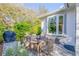 Back patio featuring wooden dining table, grill, and view of the house with large window at 65 Calumet Ave, Ponce Inlet, FL 32127