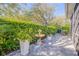 Paver patio featuring a decorative fountain, heron statues, and a dining table, surrounded by manicured hedges and lush landscaping at 65 Calumet Ave, Ponce Inlet, FL 32127