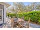 Back patio with a wooden dining set, complimented by beautiful landscaping, a decorative fountain, and sunny ambiance at 65 Calumet Ave, Ponce Inlet, FL 32127