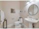 A bathroom with tile flooring, a mirror, a sink, and a toilet at 65 Calumet Ave, Ponce Inlet, FL 32127