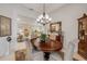 Elegant dining room with a wooden table set beneath a chandelier and a view into an adjacent living space at 65 Calumet Ave, Ponce Inlet, FL 32127