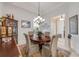 Bright dining room featuring a round wood table, elegant chandelier, and neutral decor with stylish decorative accents at 65 Calumet Ave, Ponce Inlet, FL 32127